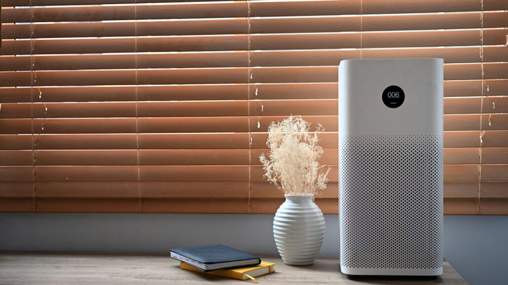 Air purifier in front of windows in living room for fresh air and healthy life.