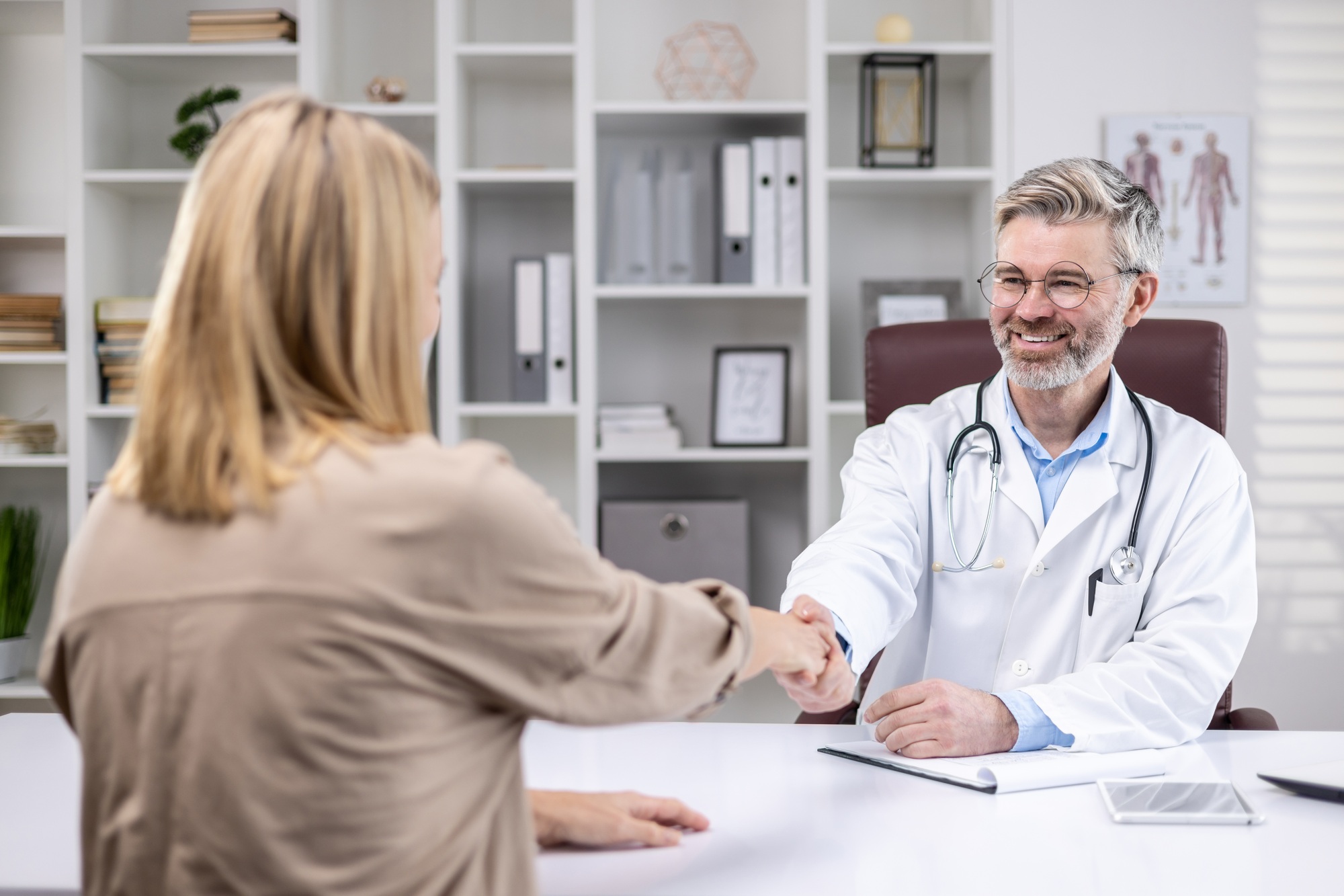 Medical consultation at the doctor, the patient shakes the doctor's hand with satisfaction, a