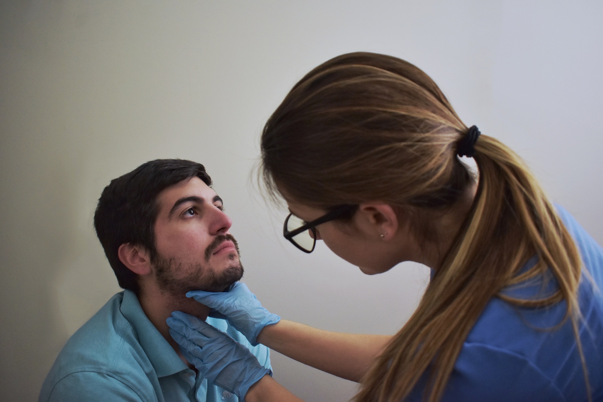 Palpating the neck during a physical exam