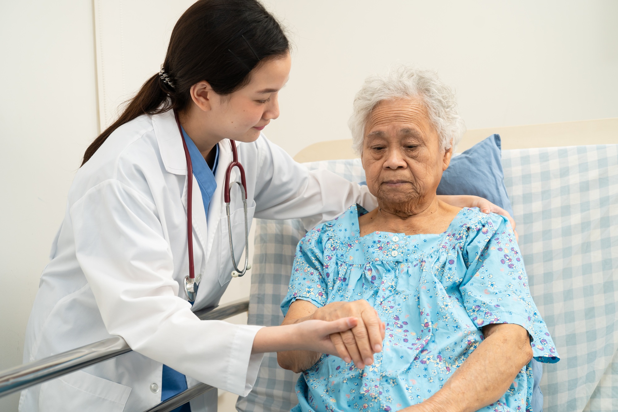 Asian doctor checking and treat elderly woman patient health in hospital.