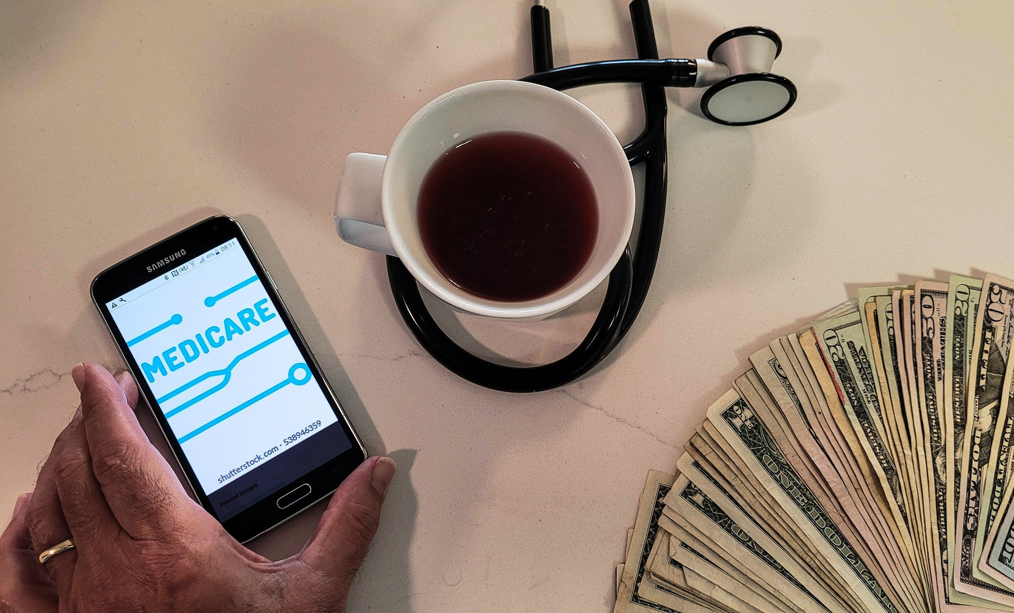 Overhead flat lay of senior heart health with money in hand for payment.